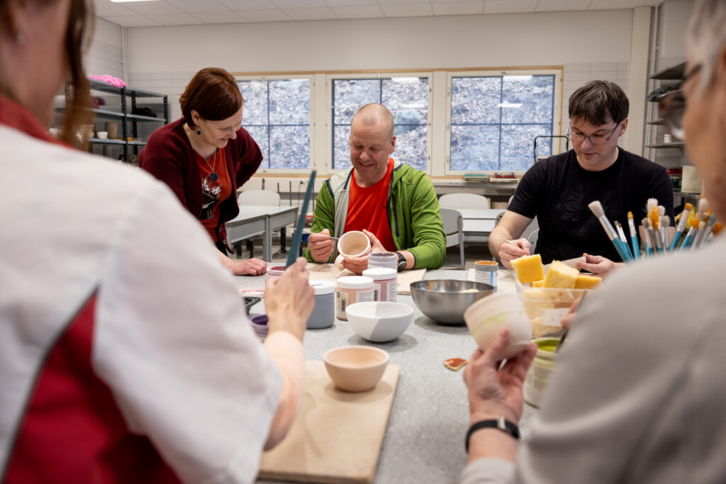 Ihmisiä harrastamassa keramiikkakurssilla