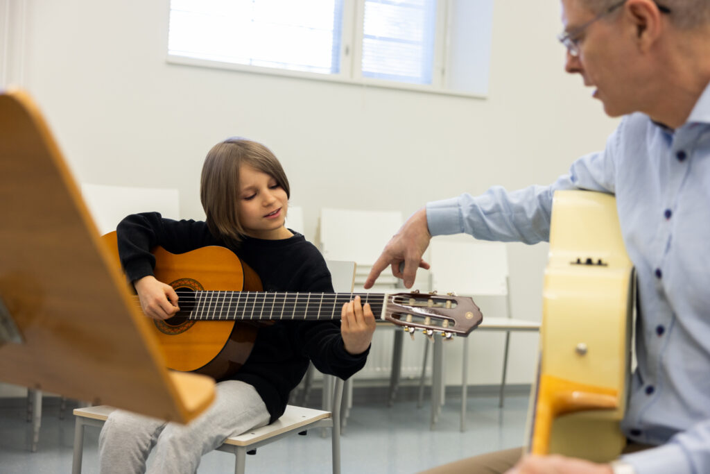 Lapsi soittaa kitaraa